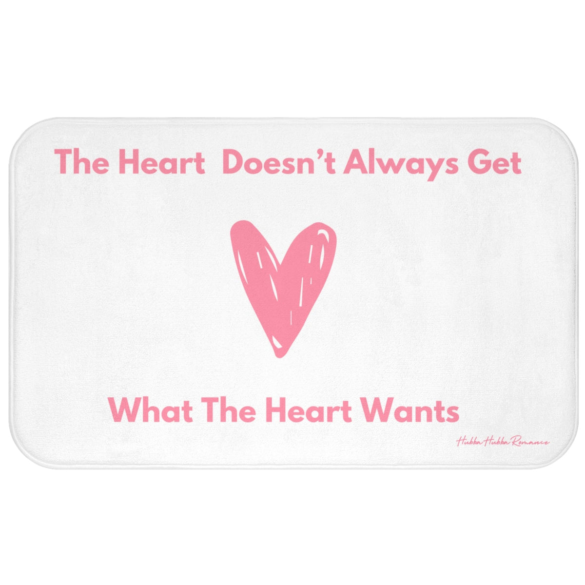 This bath mat features a clean white background with soft pink text and a large pink heart illustration at its center. The top line reads: “The Heart Doesn’t Always Get,” and the bottom line finishes the sentence: “What The Heart Wants.” The heart is hand-drawn in a casual, playful style. The overall design is minimalist and emotionally expressive. The mat features a soft, absorbent surface ideal for bathroom use, especially for romance readers who appreciate a touch of heartbreak with their hygiene. 