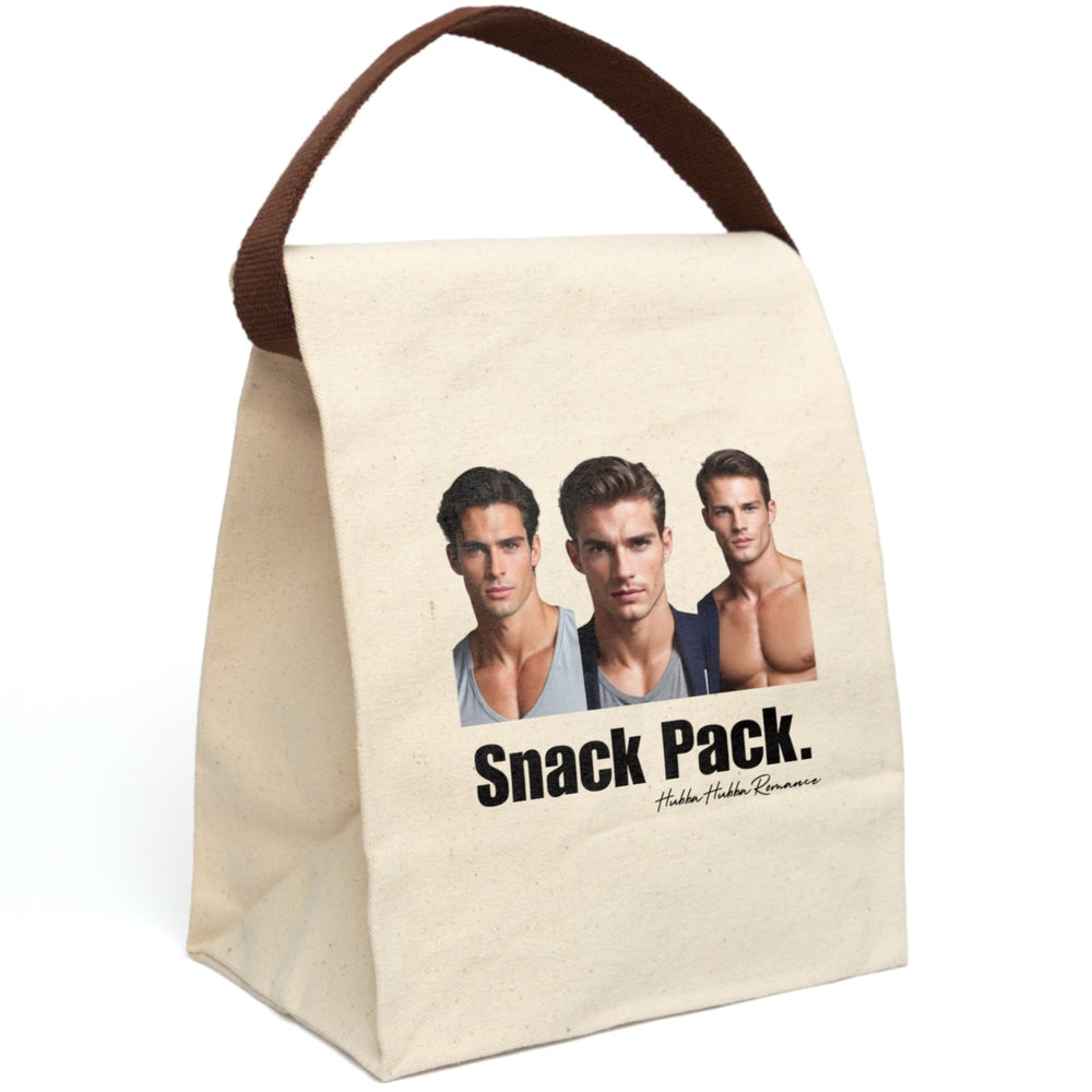 A plain canvas lunch bag features three handsome, muscular men standing side by side—styled like classic romance novel heartthrobs. One wears a snug gray T-shirt, one a blazer over a T-shirt, and the third is shirtless, showing off his sculpted chest. Beneath them, large bold text reads “Snack Pack,” cheekily implying these book boyfriends are today’s midday indulgence. The bag has a fold-over top, secure Velcro closure, and a sturdy handle, which is displayed upright, for easy carrying. 