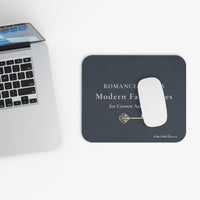 Black mouse pad with a white mouse on a desk next to a laptop