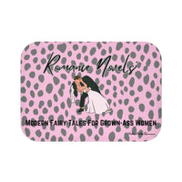 ADA Product Description:
This bath mat features a light pink background with a gray leopard print pattern. Centered near the top is the text “Romance Novels” in a black script font. Below that is an illustrated image of a groom dipping a bride into a dramatic kiss. At the bottom, bold black text reads: “Modern Fairy Tales For Grown-Ass Women.” The mat is soft and absorbent, combining playful design with a bold celebration of the romance genre. This is the smaller version.
