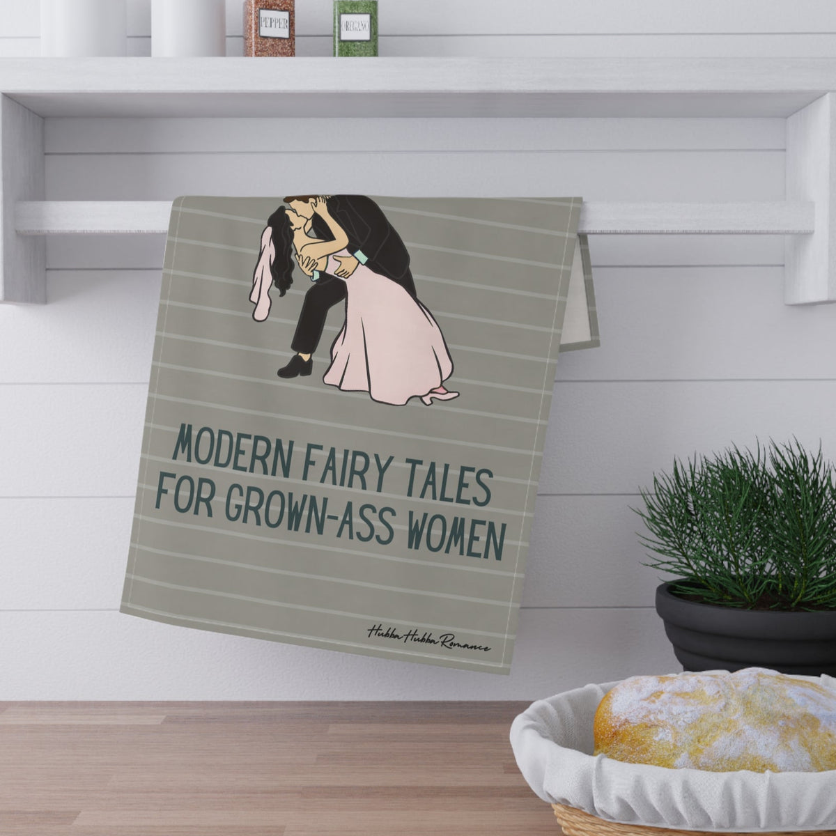 The towel is displayed by folding it over a towel bar underneath a shelf.