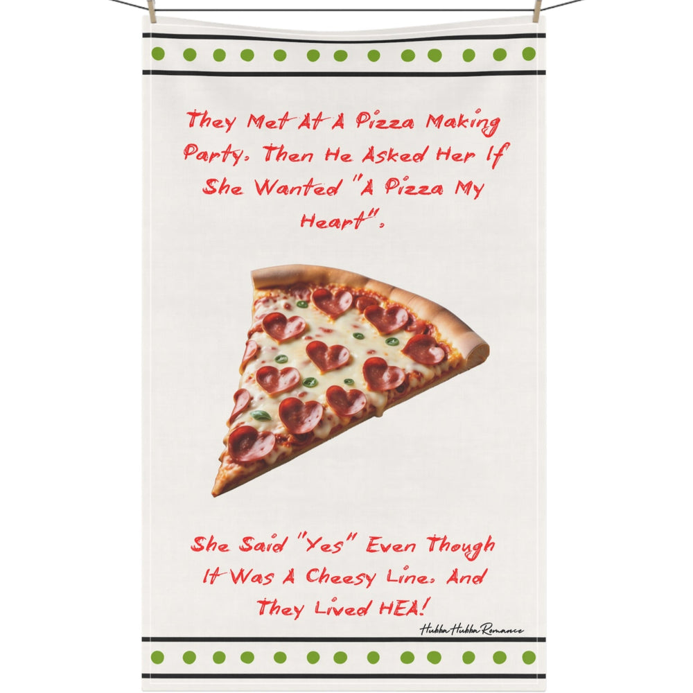 The image features a whimsical design on a cotton kitchen towel displayed on a clothesline. At the top, playful text recounts a charming story: "They Met At A Pizza Making Party, Then He Asked Her If She Wanted 'A Pizza My Heart'." Below, a large slice of pizza is adorned with heart-shaped pepperoni, symbolizing the theme of love. The text concludes with, "She Said 'Yes' Even Though It Was A Cheesy Line. And They Lived HEA!" This design cleverly combines elements of romance and humor, aimed at lovers of lig