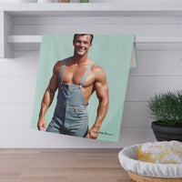 The towel is displayed by folding it over a towel bar underneath a shelf.