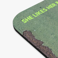 A close-up of the green textured mouse pad with rounded corners, featuring the phrase 'SHE LIKES HERBook Boyfriends Complicated.
