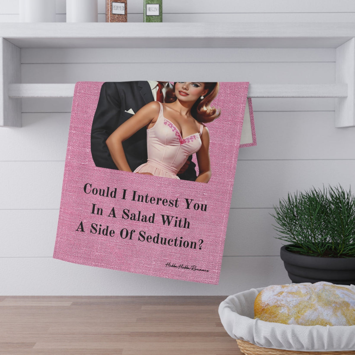 The towel is displayed by folding it over a towel bar underneath a shelf.
