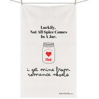 Picture of a kitchen towel hanging on a clothesline with clothespins. The towel features an outline drawing of a mason jar. In the center of the jar are the words “extra, extra, extra” over a red heart with the word “hot” under the heart. The text on the towel says: “Luckily, not all spice comes in a jar. Think Romance Novels.”