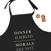 A black apron with cream colored text reading 'DINNER IS SERVED. MORALS ARE NOT.