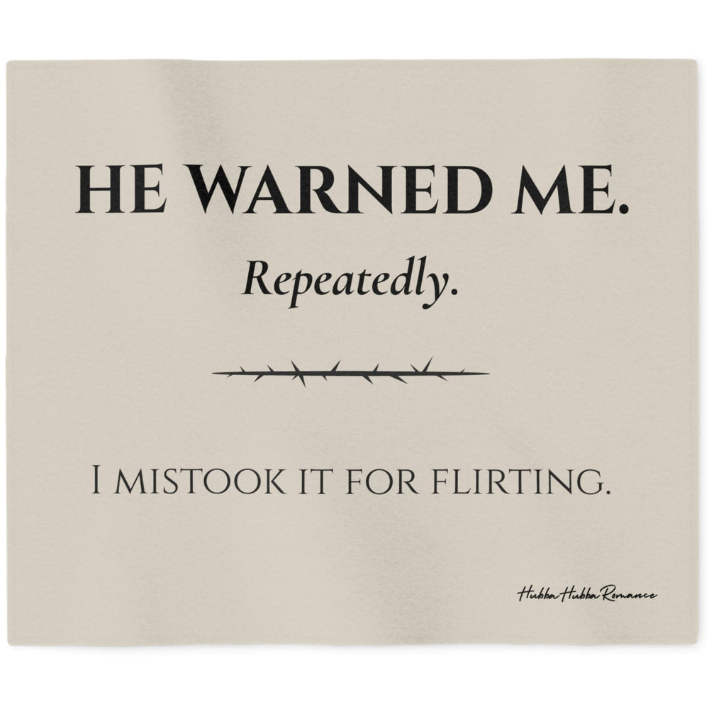 Cream-colored sweatshirt blanket featuring the dark romance quote "He Warned Me. Repeatedly. I Mistook It For Flirting." Cozy reading blanket for fans of dark romance novels, morally gray heroes, possessive love interests, and romance reader gifts.