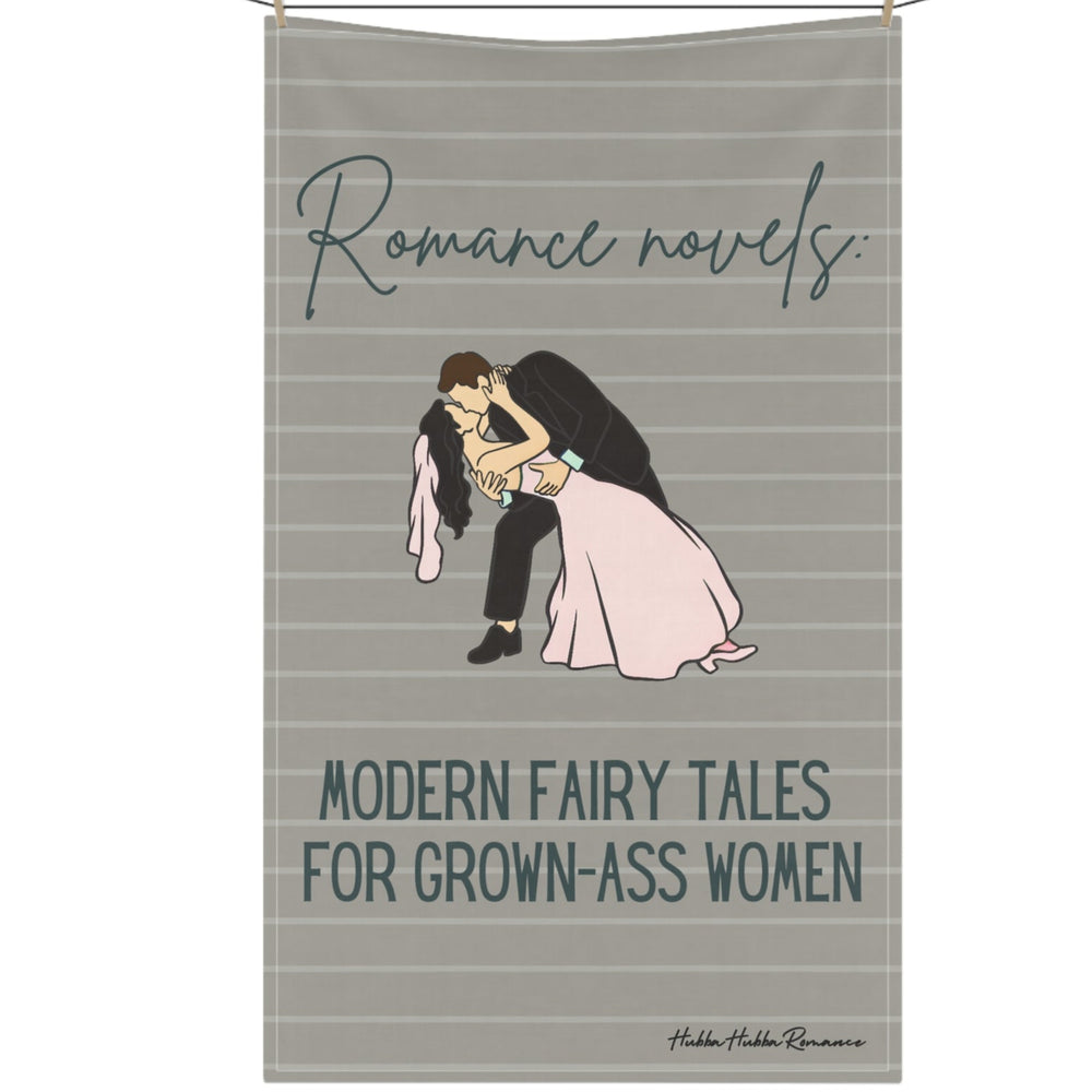 The kitchen towel is displayed on a clothesline and features a vintage-inspired design with a retro-style bride and groom in wedding attire. The groom, dressed in a classic suit, dips the bride, who wears a flowing wedding dress. Above them, vintage cursive black text reads: "Romance Novels," and below them, in block script, "Fairy Tales for Grown-Up Women." The background is taupe-ish khaki, pin-striped, giving it a nostalgic, classic romance feel. The design is perfect for book lovers of HEA endings.