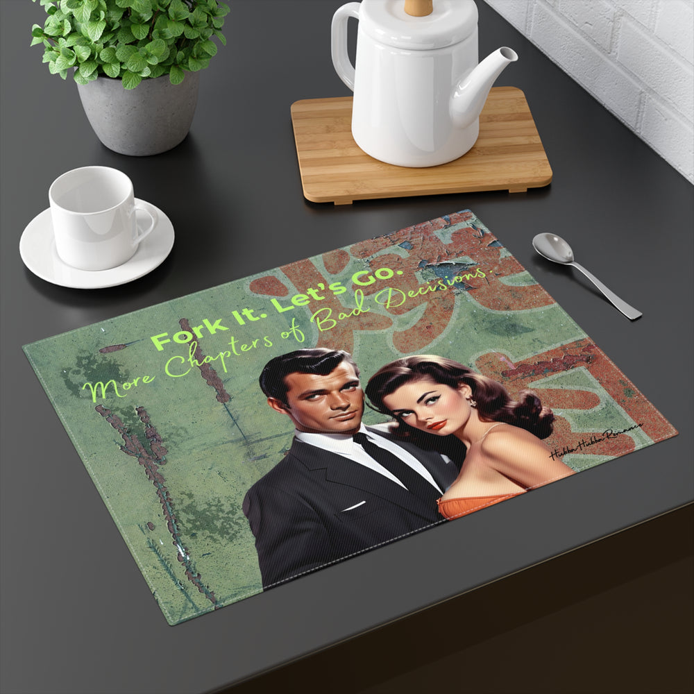 Stylized placement with vintage illustration featuring a confident mid-century couple posed  in front of a cracked green wall with distressed red lettering. The man wears a tailored black suit and tie, while the woman wears a strapless rust-colored dress with classic Hollywood waves. Light green text at the top reads, “fork it. let’s go.” Cursive lettering below says, “More Chapters of Bad Decisions,” evoking humor, romance, and impulsive energy. The placemat is shown displayed as part of a table setting.
