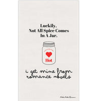 Picture of a kitchen towel with an outline drawing of a mason jar. In the center of the jar are the words “extra, extra, extra” over a red heart with the word “hot” under the heart. The text on the towel says: “Luckily not all spice comes in a jar. I get Mine From Romance Novels.”

