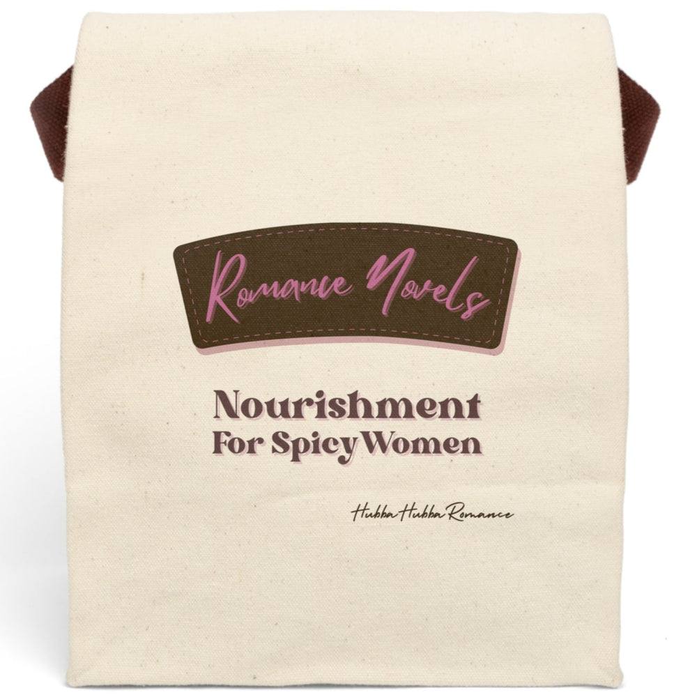 This lunch bag features a plain canvas background with two prominent text sections. At the top, a stylized brown label with pink stitching contains the words “Romance Novels” in a cursive pink font. Below the label, bold pink and brown text reads: “Nourishment For Spicy Women.” The design resembles a vintage food label with a modern, sassy twist. The bag is made of durable canvas with a roll-top closure and a carrying strap, perfect for everyday use.