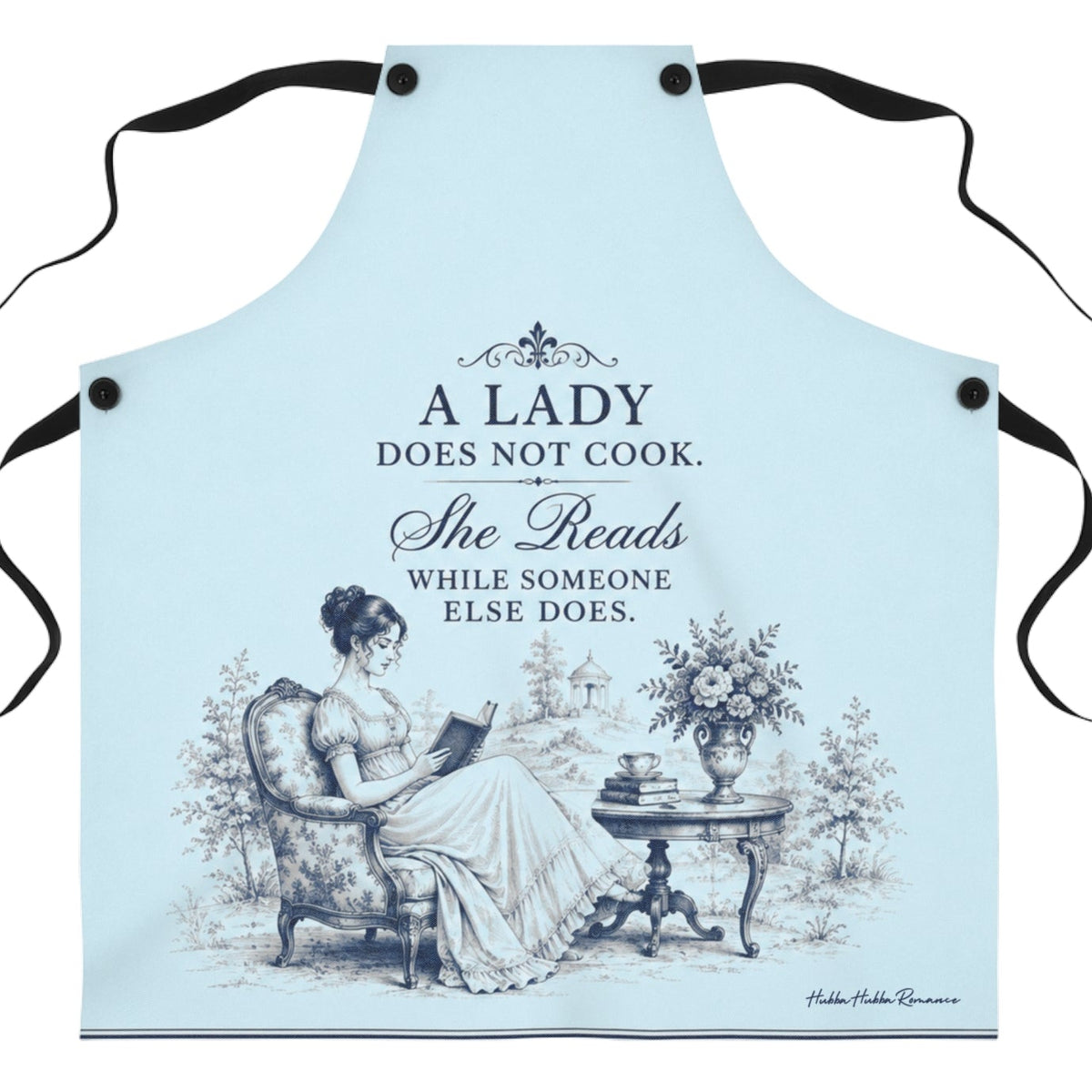 A light blue kitchen apron with black neck and waist ties, featuring a vintage illustration of a lady reading and the text 'A LADY DOES NOT COOK. She Reads WHILE SOMEONE ELSE DOES.