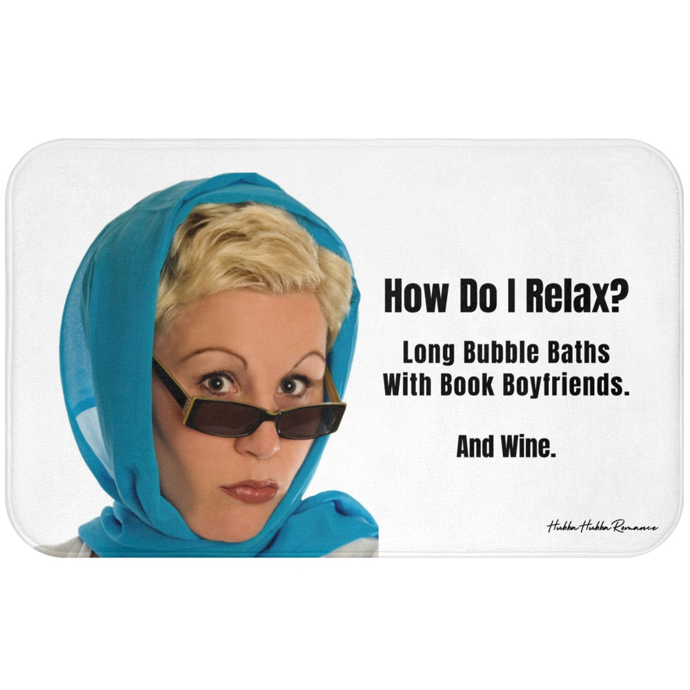 This bath mat features a retro-style image of a woman with short blond hair, wearing a turquoise headscarf and sunglasses, giving a dramatic stare. To the right of her, bold black text reads: “How Do I Relax? Long Bubble Baths With Book Boyfriends. And Wine.” The background is white, and the design blends humor with a glamorous vintage vibe. The mat is soft, absorbent, and ideal for romance readers with a flair for the dramatic.This is the larger size.
