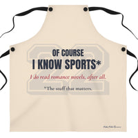  a beige apron that features the text 'OF COURSE I KNOW SPORTS*' in dark blue, with red  text below reading 'I do read romance novels, after all. The last line, in dark blue, reads *the stuff that matters. There is a very faint 22 in a sports font behind the text.