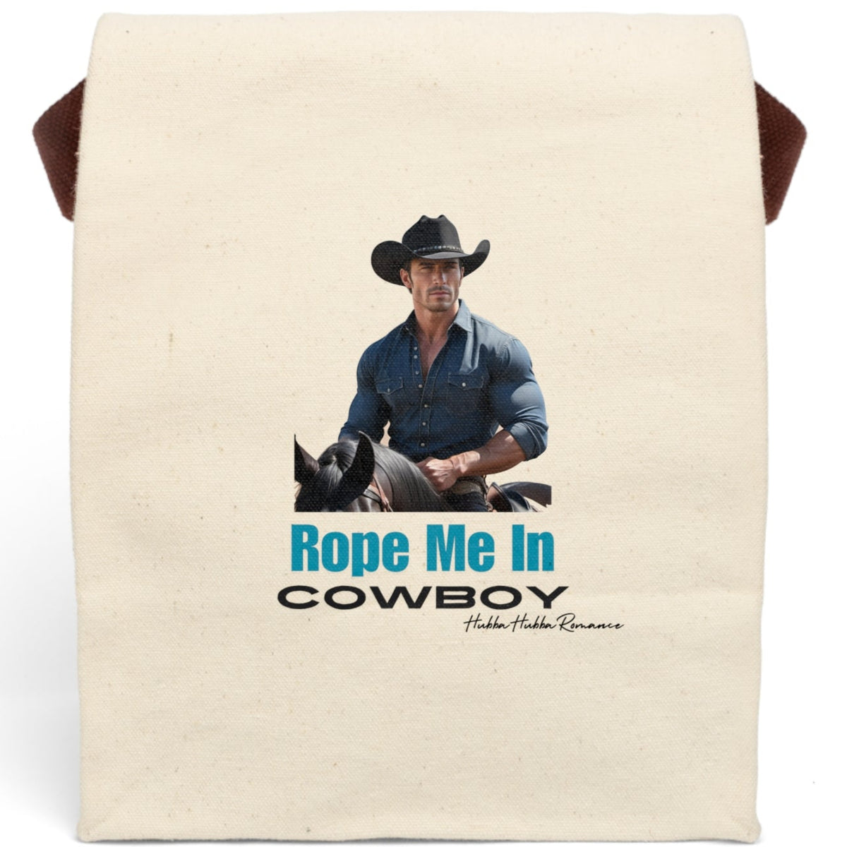 This canvas lunch bag features a full-color image of a muscular, chiseled cowboy riding a black horse. He wears a fitted denim button-down shirt and a black cowboy hat with silver details. His arms are crossed on the saddle, and he gazes ahead with intensity. Below the image, bold turquoise text reads “Rope Me In” followed by black block letters that say “COWBOY.” The bag includes a canvas strap and roll-top closure.