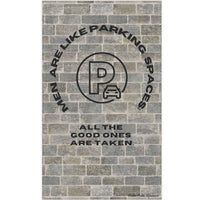The image depicts a cotton kitchen towel with a vintage-style design, set against a textured brick wall background. At the top, arched black text reads: "Men Are Like Parking Spaces." Below, a circular stamp-like emblem resembles a classic parking permit, with a distressed, worn effect. The stamp has bold block letters and a faded appearance, enhancing its retro feel. Beneath the stamp, additional black text reads: "All the Good Ones Are Taken." The combination of the brick texture and faded stamp design gi