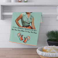 The towel is displayed folded over a rod under a shelf.