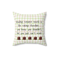 This 16-inch pillow features a white, light pink, and light green plaid background with black handwritten text that reads: "Reading romance novels is like eating chocolate… you know you shouldn’t, but you just can’t resist." Below the text, five illustrated chocolate pieces with a glossy, melting effect are lined up in a row. The overall design has a cozy, playful feel, combining a love for romance books with the indulgence of chocolate.