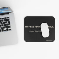 Mouse pad  next to a laptop on a white surface