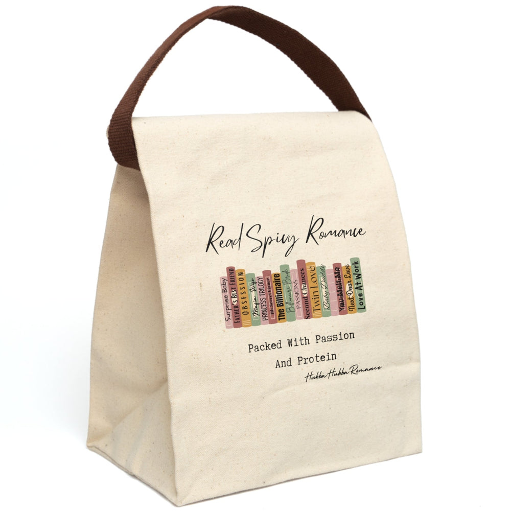 This canvas lunch bag features an illustrated row of romance book spines in muted earth tones, each labeled with tropes or titles like “Surprise Baby,” “Obsession,” “His Secret Fiancé,” “Twin Love,” and “Next Door Love.” Above the books, flowing script reads “Read Spicy Romance.” Below, in bold typewriter-style font, it says: “Packed With Passion And Protein.” The design blends a cheeky tone with a love for books. Bag includes canvas carrying strap, displayed upright, and roll-top closure.