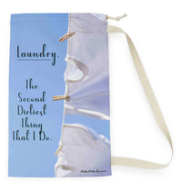 This laundry bag features a high-resolution photo of two white tank tops pinned to a clothesline against a bright blue sky. Flowing across the left side of the design is a playful message in elegant black text: “Laundry. The second dirtiest thing that I do.” The visual combines clean imagery with cheeky humor, making it a fun and functional bag for readers who love steamy romance and tidy piles. The bag has a drawstring closure and a large canvas strap for carrying. This is the small version.
