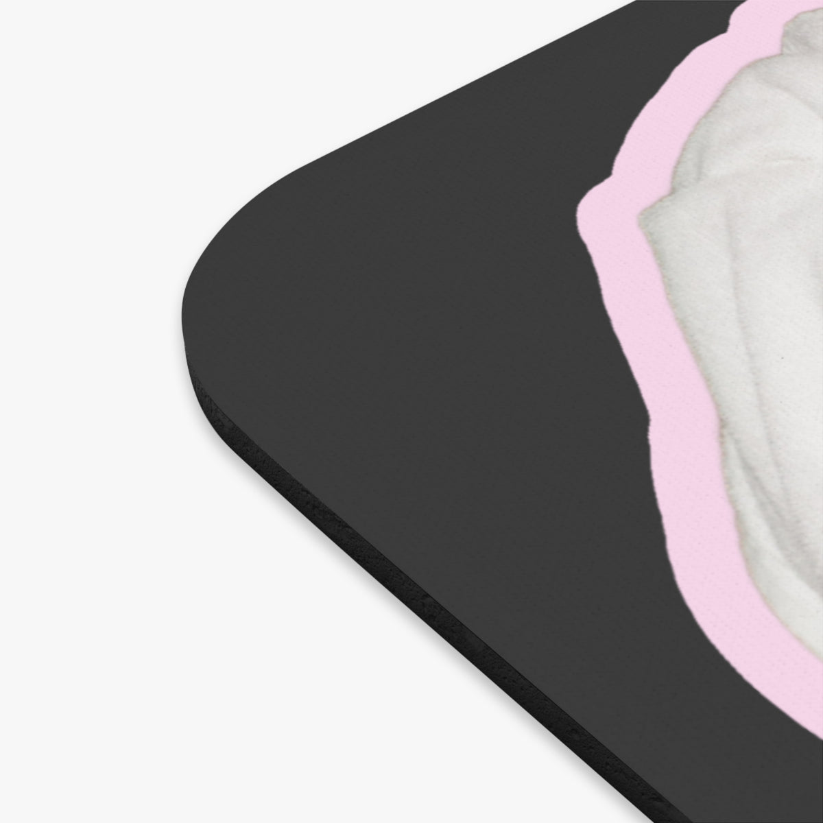 Close-up of a black rectangular mouse pad with rounded corners, showing a light pink border and a white textured inner layer on a plain white background.