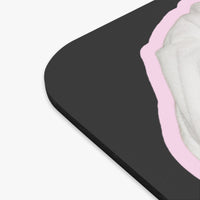 Close-up of a black rectangular mouse pad with rounded corners, showing a light pink border and a white textured inner layer on a plain white background.