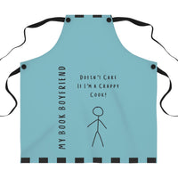 A teal apron with black straps. The apron features the phrase, "My Book Boyfriend" written vertically on the left side and "Doesn't Care If I'm a Crappy Cook!" in the center. A simple stick figure illustration is below the text. The apron has black square accents along the top and bottom edges. 