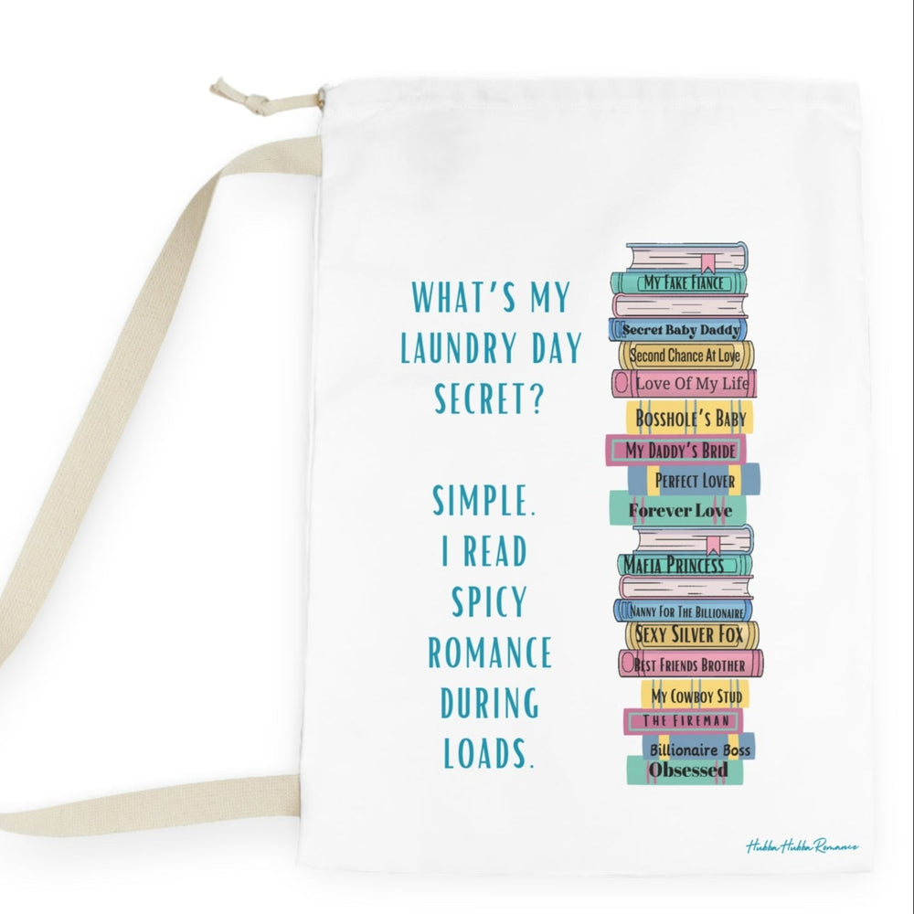  This is an image of an off white laundry bag lying flat on its side. It has a drawstring enclosure at the top and a large canvas carrying strap on the side. The bag has an image of a large stack of romance books with various spicy titles. Next to the stack is text that says: What's My Laundry Secret? Simple. I read Spicy Romance During Loads. This is the larger bag.