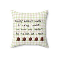 This 18-inch pillow features a white, light pink, and light green plaid background with black handwritten text that reads: "Reading romance novels is like eating chocolate… you know you shouldn’t, but you just can’t resist." Below the text, five illustrated chocolate pieces with a glossy, melting effect are lined up in a row. The overall design has a cozy, playful feel, combining a love for romance books with the indulgence of chocolate.