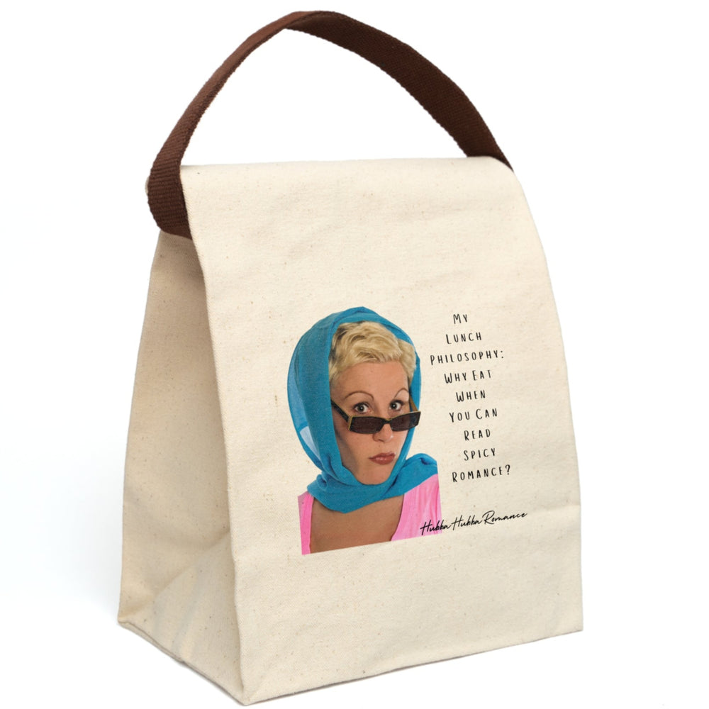 This canvas lunch bag features a retro-inspired image of a blonde woman wearing a bright blue headscarf and sunglasses. She has a bold, confident expression. To the right of her, in a casual black font, the text reads: “My Lunch Philosophy: Why Eat When You Can Read Spicy Romance?” The background is white, and the design channels vintage glamour with a sassy, modern bookish twist. The bag includes a roll-top closure, canvas strap, and durable material for everyday use. The strap is displayed upright.