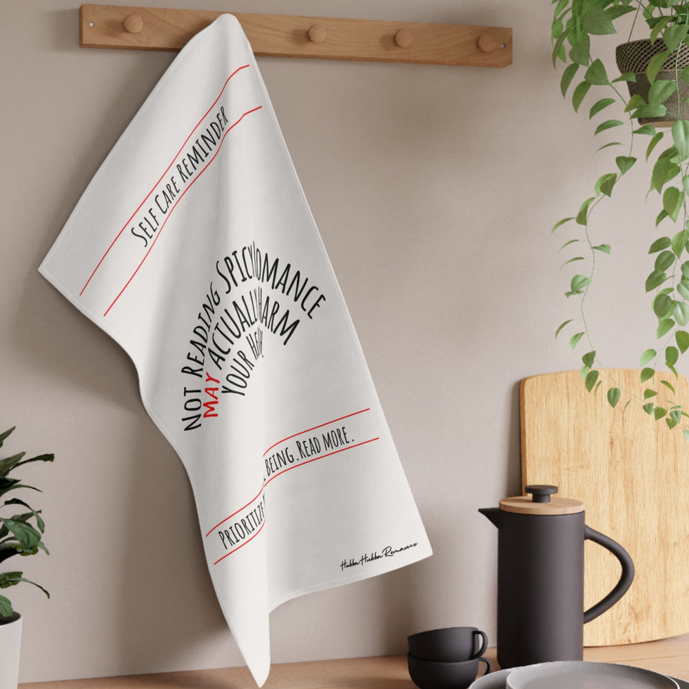 The towel is displayed on a wall hook in a kitchen setting.
