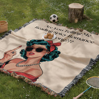 The blanket is being displayed as a picnic blanket in a park setting with a tree stump, picnic basket, plate of muffins, and a tennis racquet and a soccer ball lying around.
