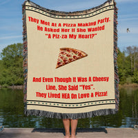 This woven blanket features a playful story about love and pizza, paired with an image of a heart-shaped pepperoni slice. There is a row of green dots between two black lines at the top and the bottom of the blanket as a decorative accent. The large font vibrant red text telling the story stands out on a creamy yellow background, offering cozy comfort and cheeky charm for romance readers. Soft, durable, and machine washable. The blanket has colorful cotton fringed edges. 