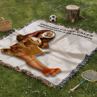 Vintage-inspired woven blanket spread on green grass featuring a retro brunette reader doll with a pink streak in her hair and the phrase “Modern Fairy Tales for Grown Ass Women.” Cozy romance reader blanket displayed in an outdoor picnic setting with basket, tree stump, and badminton racket.