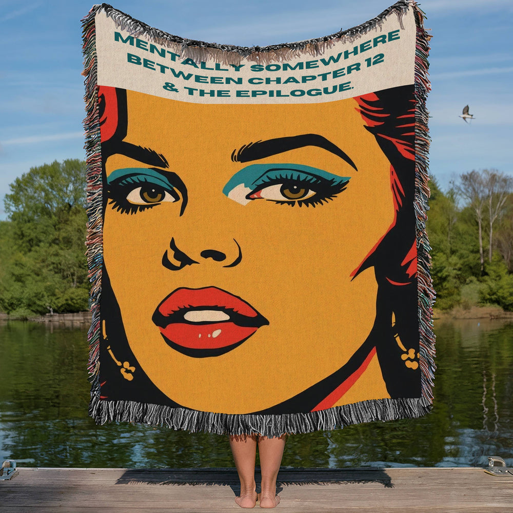Colorful woven cotton fringe blanket featuring vintage-inspired pop art woman artwork displayed on a lakeside dock, designed for readers who love romance novels. the phrase "Mentally Somewhere Between Chapter 12 & The Epilogue," designed for romance readers, book lovers, and bookish home décor enthusiasts.