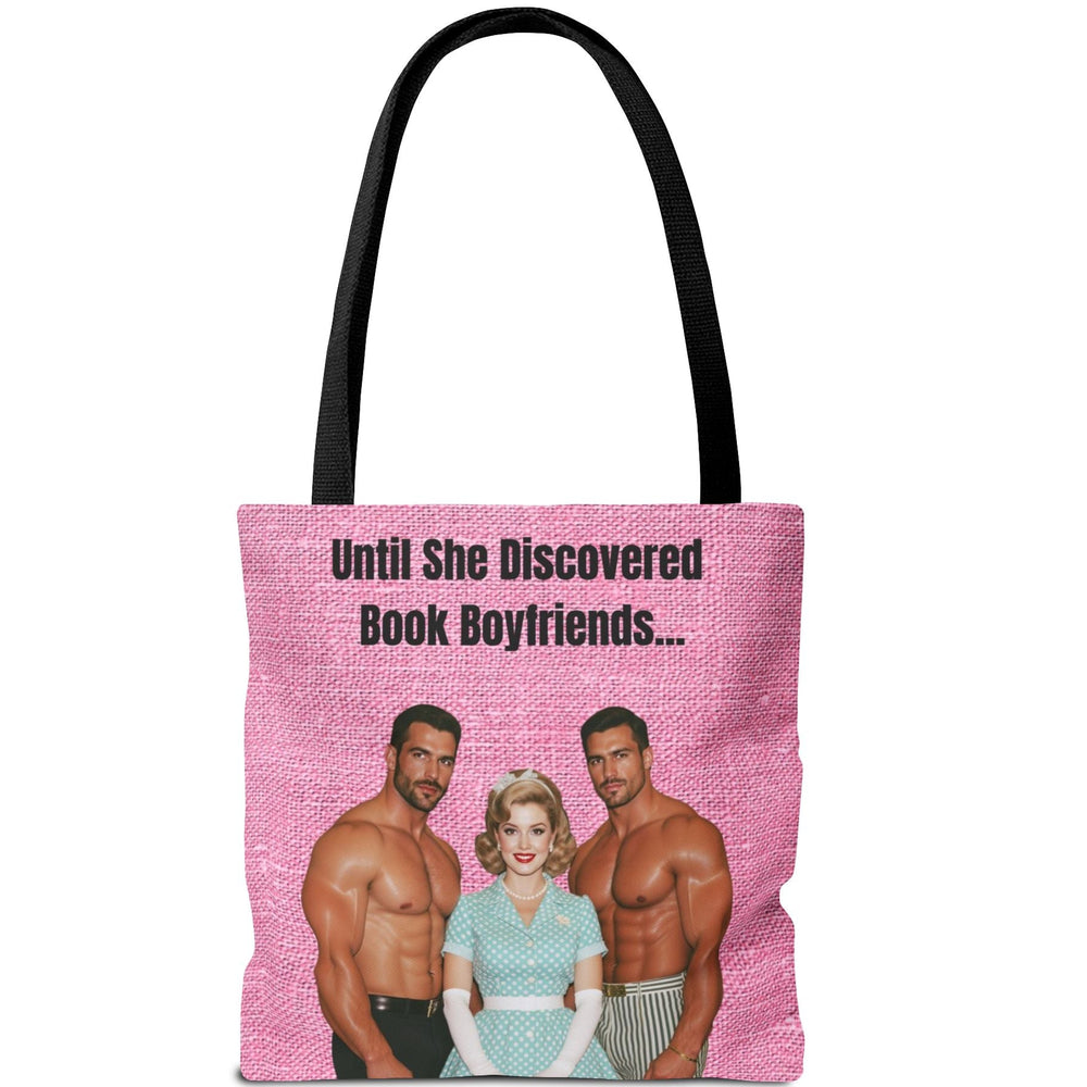 Image features a double-sided tote with a hot pink textured background and bold black text. One side says “She Was A Good Girl…” and the other reads “Until She Discovered Book Boyfriends…” The center image on both sides shows a retro-styled blonde woman in a 1950s polka dot dress, pearls, and gloves, flanked by two shirtless, muscular men. The design blends vintage housewife innocence with cheeky romance humor, celebrating the steamy transformation that comes from reading spicy books.