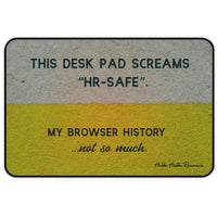 A horizontal desk mat with a textured background of muted yellow and gray tones. The top text reads “THIS DESK MAT SCREAMS ‘HR-SAFE’.” Below it, smaller text says, “MY BROWSER HISTORY ...not so much.” All text is in black and capitalized except the final line, which is lowercase and cursive.