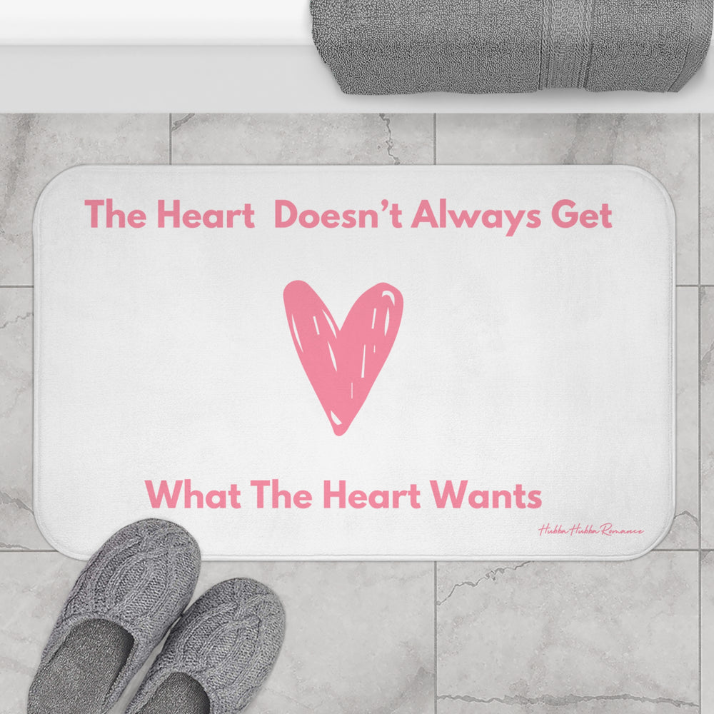 The bath mat is displayed next to a tub with a pair of slippers for size context.
