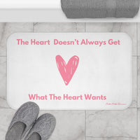The bath mat is displayed next to a tub with a pair of slippers for size context.
