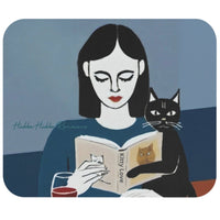 This mouse pad is a drawing of a woman with black hair sitting at a table with a glass of wine, reading a book called Kitty Love. Next to her is her cat. The background is a blue wall.
