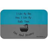 This bath mat features two background colors: teal on the top half and gray on the bottom half. The top half includes playful black text that reads: “I Like My Men How I Like My Bath Time.” Centered in the lower half is a black graphic of a vintage-style bathtub with a shower head spraying water. Below the tub, curved black text reads: “Hot And Steamy.” The mat is soft, absorbent, and designed for romance readers with a cheeky sense of humor.
This is the larger sized mat.