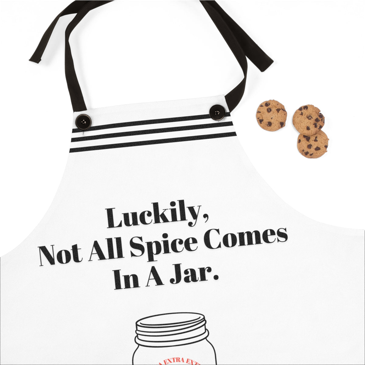 A close up of the white apron with black straps and a humorous design. The apron features the phrase, "Luckily, not all spice comes in a jar" .