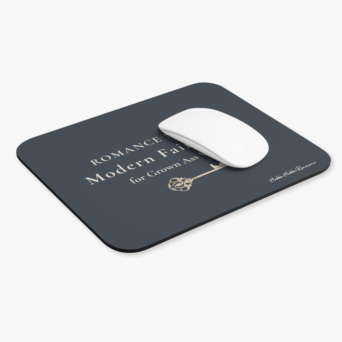 Dark gray mouse pad with some cream text covered by a white mouse on a white background