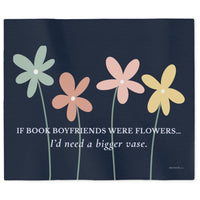 A rectangular dark navy sweatshirt blanket featuring four stylized flowers in pastel green, peach, pink, and yellow with the text, 'IF BOOK BOYFRIENDS WERE FLOWERS.I'd need a bigger vase.