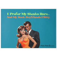 Glass cutting board with a turquoise blue background. Features a glamorous vintage couple, the woman in a orange dress and the man in a dark suit. The text above them reads: “I prefer my steaks rare” in a lime green vintage text... “and my book boyfriends filthy in a bright orange vintage text.” Made of durable tempered glass with non-slip rubber feet for countertop use. This is the larger size.

