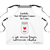 A white apron with black straps and a humorous design that features the phrase, "Luckily, not all spice comes in a jar," with an illustration of a spice jar labeled "Hot" and "Extra Heat Level" inside a red heart. 