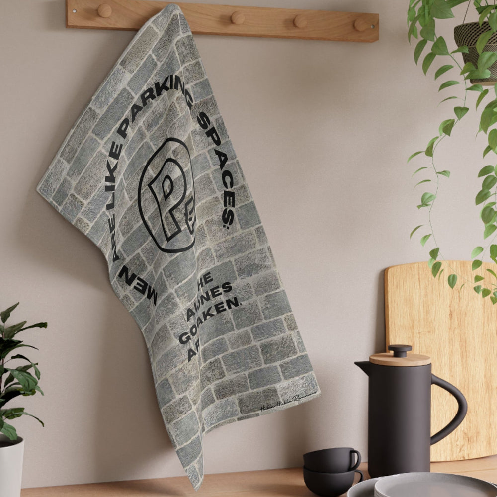 The towel is displayed on a wall hook in a kitchen setting.
