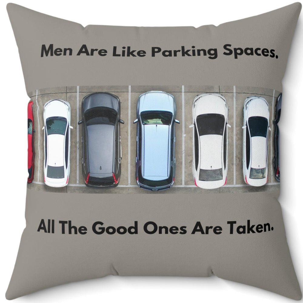 A 20-inch pillow features an overhead view of a row of parked cars in a parking lot. Above the image, bold black text reads: "Men Are Like Parking Spaces." Below the image, matching text continues: "All The Good Ones Are Taken." The background is a muted grayish-green, allowing the text and image to stand out. The design is playful and sarcastic, making a humorous comparison between dating and the struggle to find an available parking spot. 